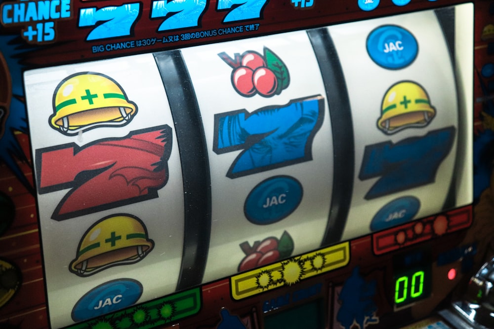 Layar mesin slot menampilkan simbol tujuh — tiga angka tujuh berjajar