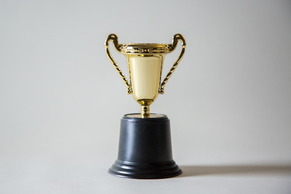 Piala emas di atas podium — turnamen slot mingguan